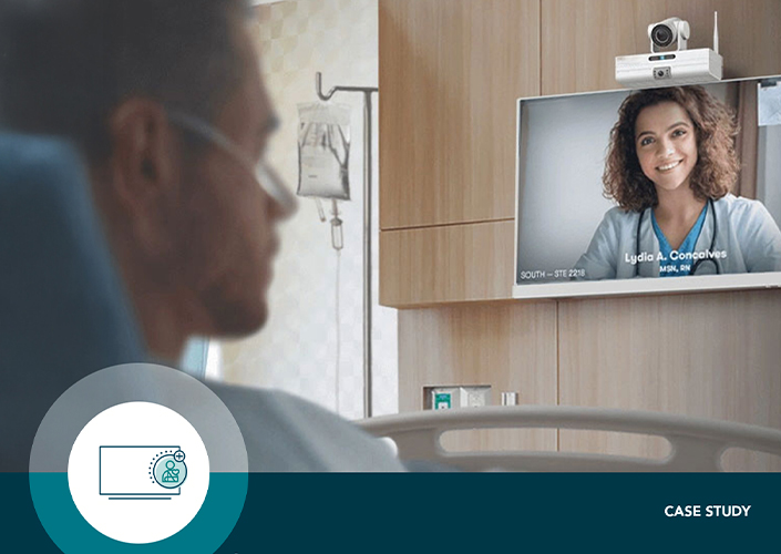 A young male in a hospital bed at Henry Ford Health faces away from the camera to consult with his virtual nurse, a young white female, on SONIFI Health's interactive TV system